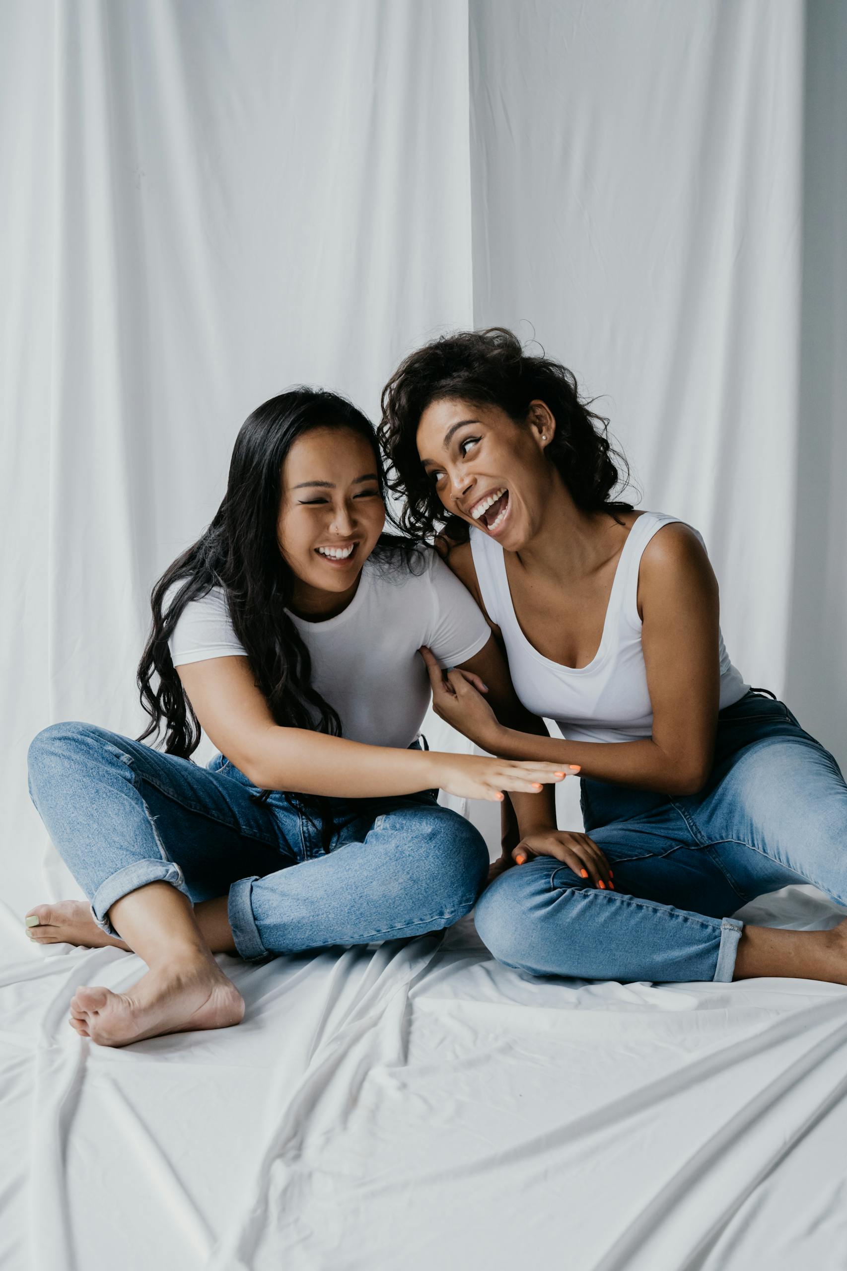 Women Wearing White Tops and Denim Pants